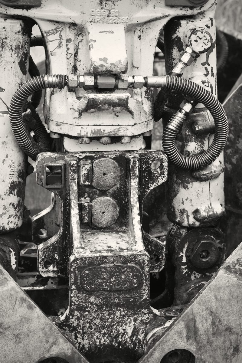 Black and white close-up of a worn machine housing and fittings